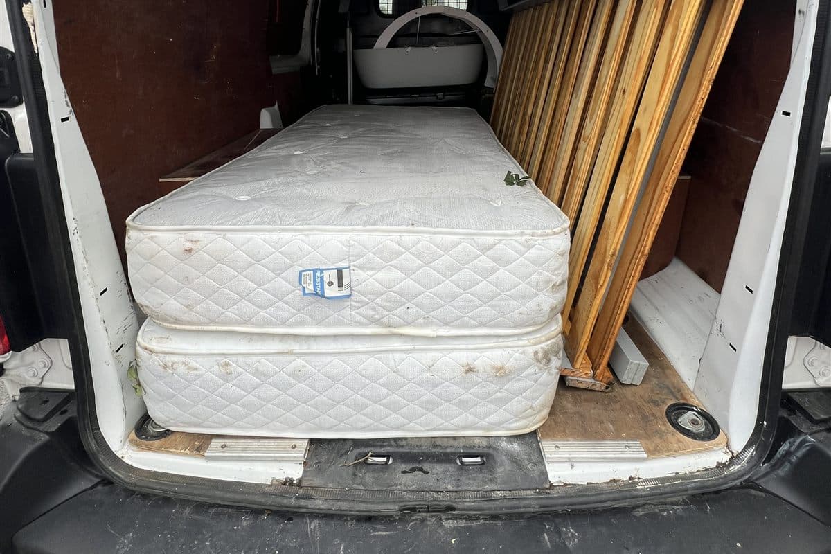 Mattresses and furniture loaded into a van for waste collection